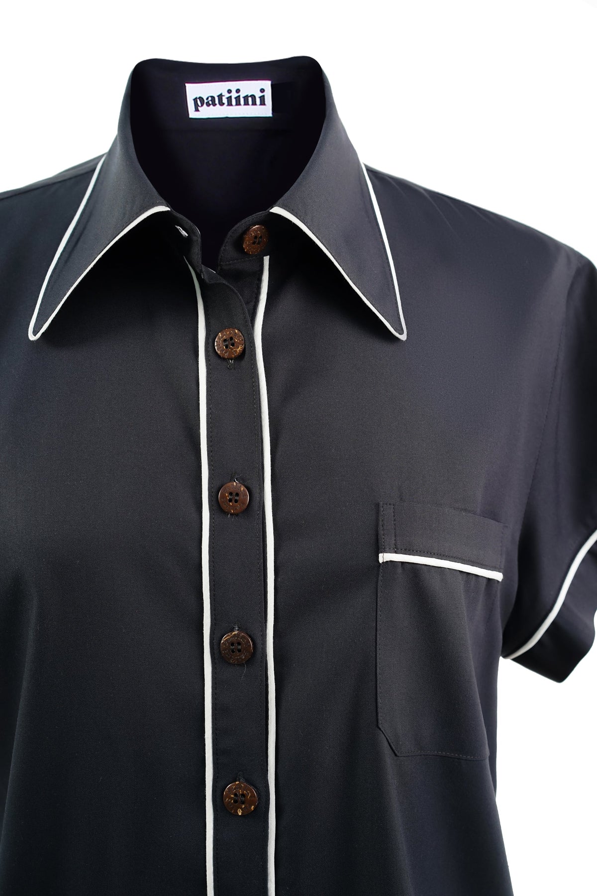 Close-up of a black short-sleeved button-down with coconut shell buttons.