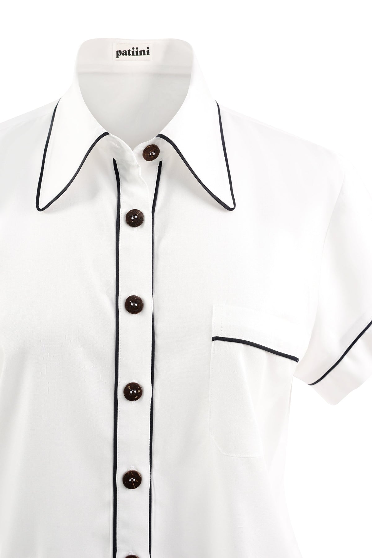 Close-up of a white short-sleeve pajama shirt with coconut shell buttons.