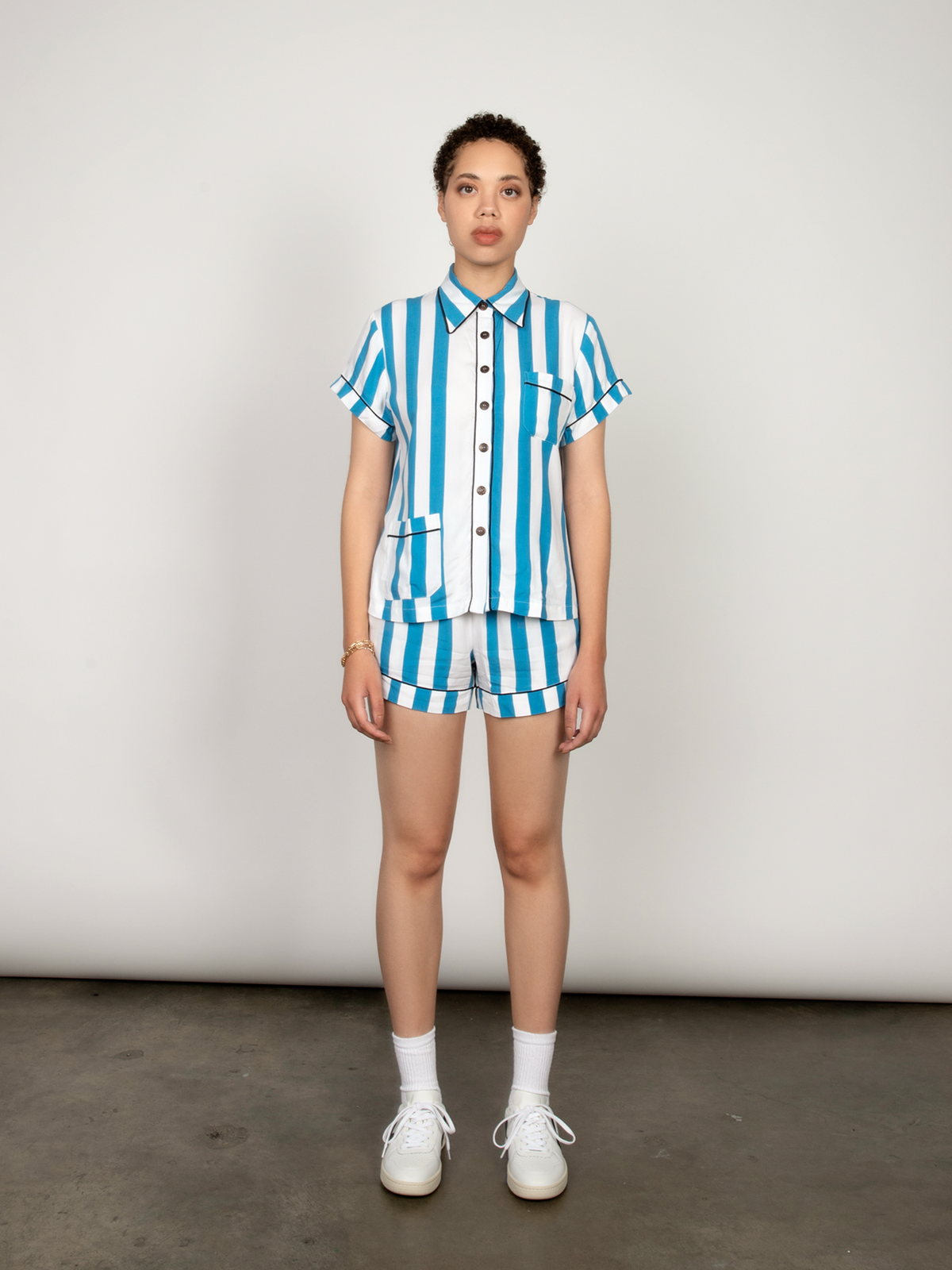 Woman wears a blue and white striped short-sleeved pajama set.