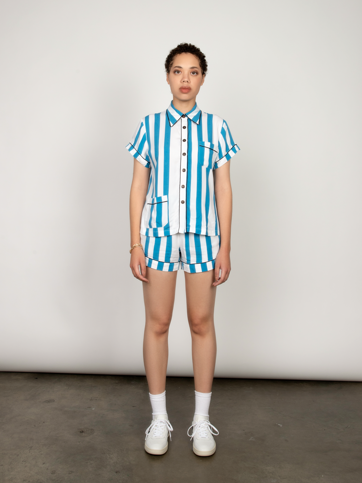 Blue and white striped short-sleeve pajama shirt with contrasting black piping.
