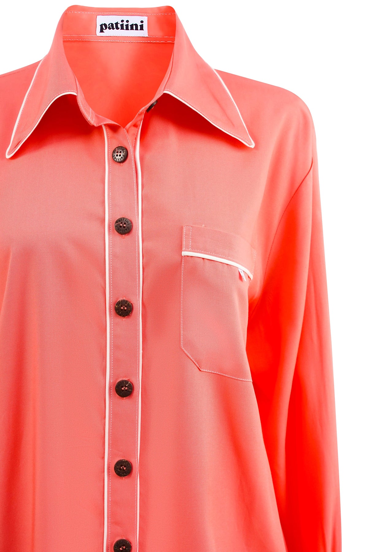 Close-up of a coral button-down pajama shirt coconut shell buttons.