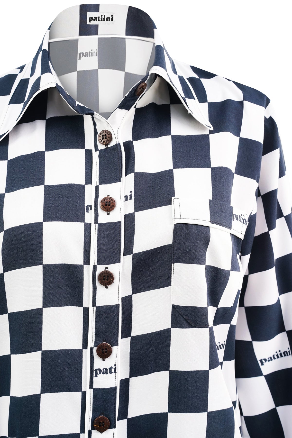 Close up of black and white checkered shirt with coconut shell buttons.Woman with her back turned wears a black and white checkered pajama set.